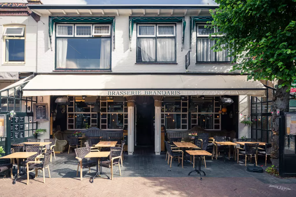 Brasserie Brandaris in Terschelling: Einladendes Restaurant mit Außenbereich und Tischen unter einem Sonnenschutz.