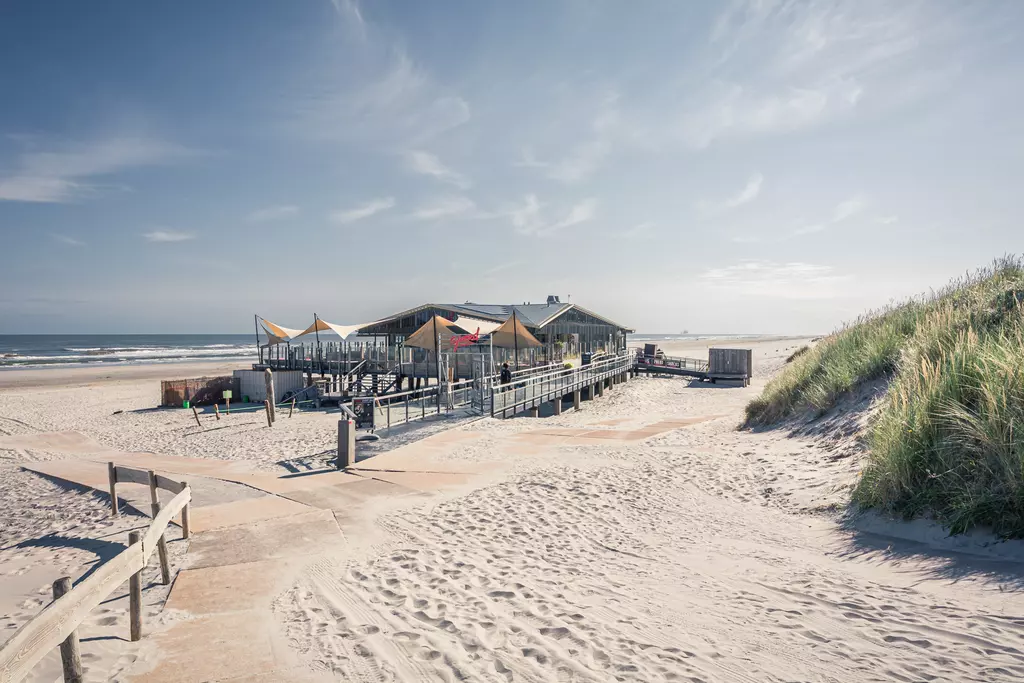 Strandrestaurant mit Holzterrasse und Blick aufs Meer.