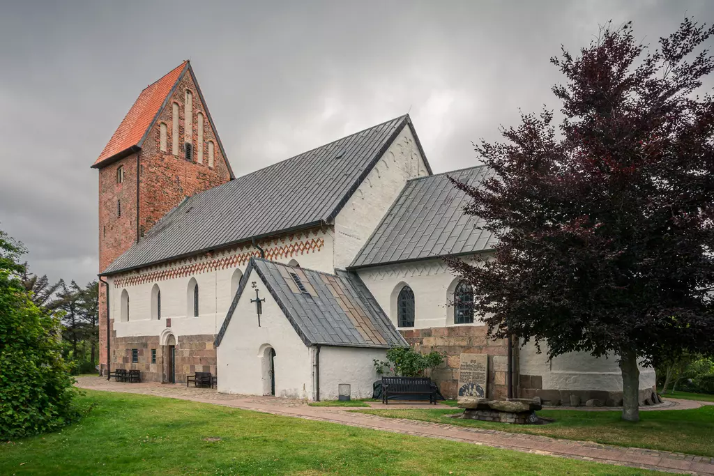 St.-Severin-Kirche in Keitum: historische Backsteinarchitektur mit einem markanten Turm und umliegendem Grün.