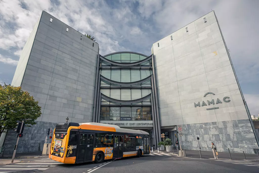 MAMAC in Nice: Modern architecture of the museum for modern and contemporary art with an orange bus in the foreground.