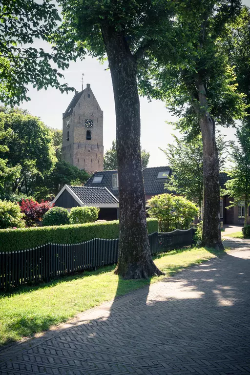 Historische Allee mit Blick auf den markanten Kirchturm von Nes.