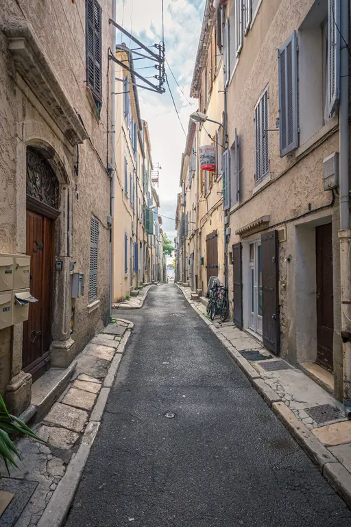 A narrow street in La Ciotat lined with traditional buildings and bicycles, showcasing the charm of a historic French town.